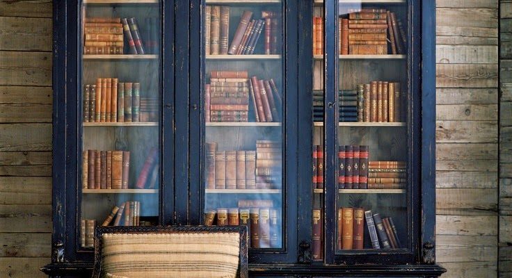 Ralph Lauren interior, painted and antiqued black book case, antique chair.