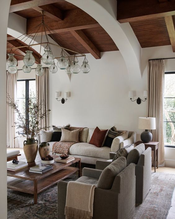 Wood paneled, vaulted barrel ceiling in a spacious living room furnished in neutral tones.