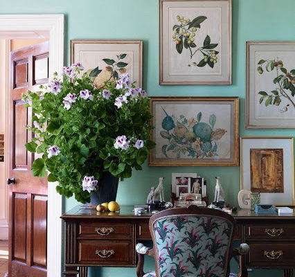 Aqua walls, antique botanicals, a mahogany desk and upholstered chair with large bouquet.