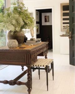 Natural products and natural materials like this vintage wood desk and stool with pottery and plants creates a natural look in the home and has low emissions. 