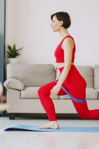 woman working out at home using at home equipment, yoga mat and bands