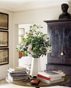 Hutch with black over blue decorative 'glaze' finish, hall table and fresh flowers in a light filled room